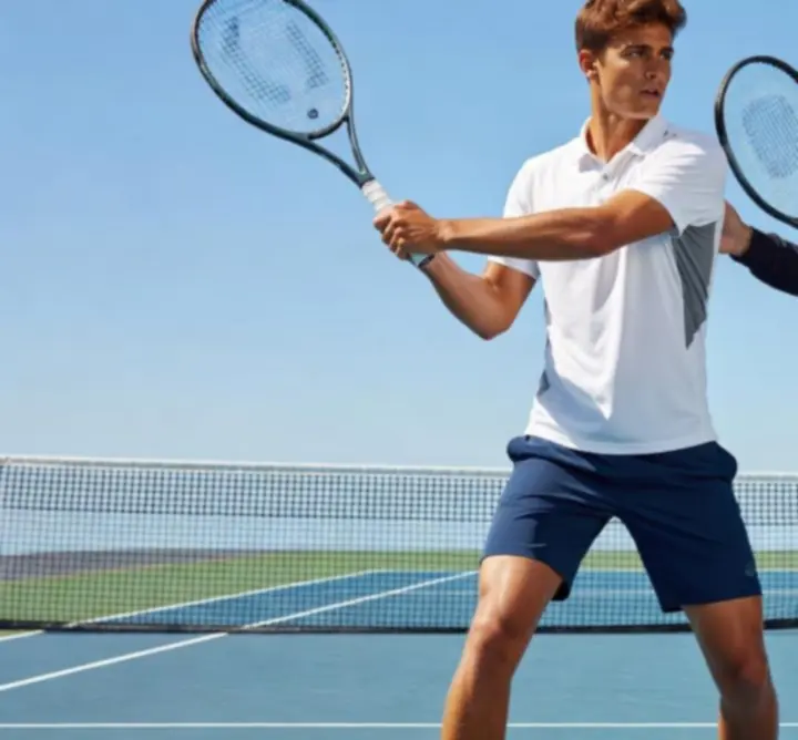 Joueur de tennis débutant effectuant un coup droit sur un court en dur